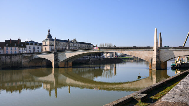 Symmetrical view of historic bridge and dome with calm water Chalon sur Saone