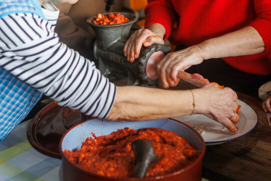 Hands making traditional pork sausages with meat grinder