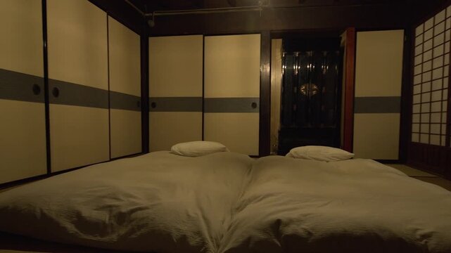 Panning across traditional Japanese bedroom with two futons on tatami