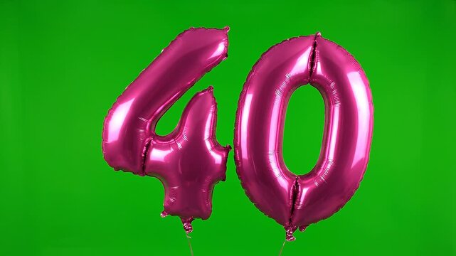 Pink foil balloon number 40 floating on green screen background