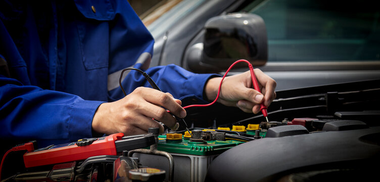 Mechanic using multimeter for automotive electrical system diagnostics
