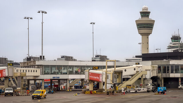 Amsterdam Schiphol airport control tower and jet bridge on a cloudy