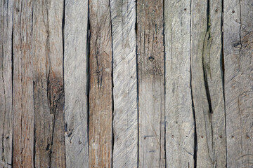 full frame texture of old weathered wooden planks arranged vertically with rough grain cracks and gray color for rustic background