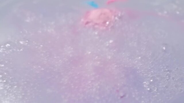 Close Up of a Colorful Fizzy Bath Bomb Dissolving in Water.