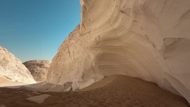 White limestone rock formation and sand dunes in Sahara Desert. Moon Cave in White Desert National Park