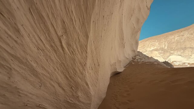 Close up motion along the white limestone wall of rock in Sahara Desert