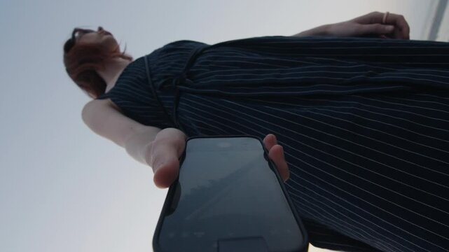 Woman dropping her smartphone on the sand at the beach