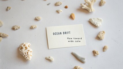 Elegant beach-themed flat lay featuring natural textures, coral pieces, and a serene ocean-inspired card design
