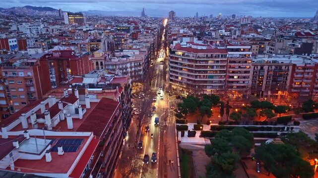 Long straight street in Eixample district of Barcelona at dusk, Spain. Aerial forward