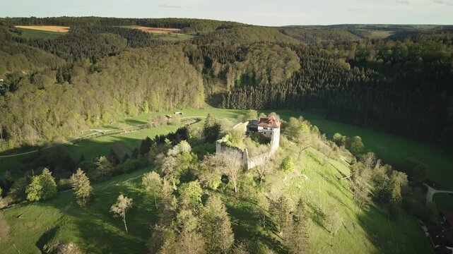 Smooth 4K UHD drone push-in flying forward toward Burgruine Niedergundelfingen on the Schlo&szlig;berg above the Gro&szlig;e Lauter valley near M&uuml;nsingen-Gundelfingen, Swabian Alb, Baden-W&uuml;rttemberg, Germany.