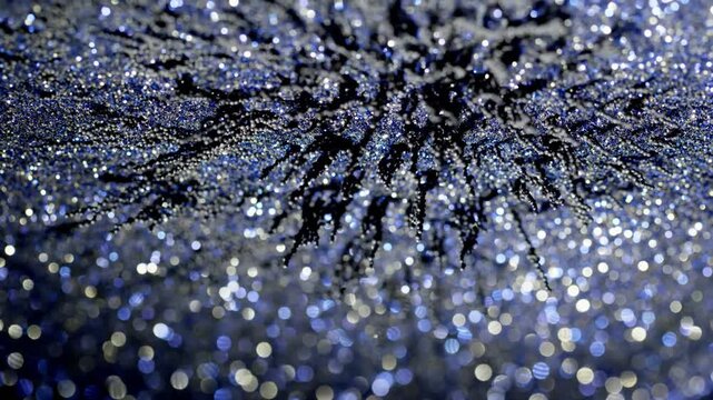 Shimmering multicolored glitter particles on a dark textured surface