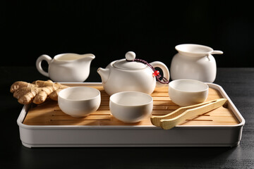 Fototapeta premium Ceramic tea set on tray against dark background
