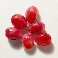 Cluster of red grapes on white surface  