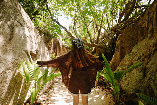 Young woman in leopard scarf brown shirt and beige shorts joyful