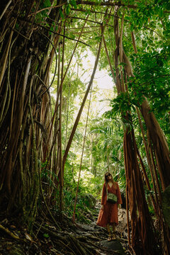 Long-haired woman in brown polka dot dress sunglasses khaki bag