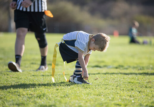 Flag football player tying his shoes