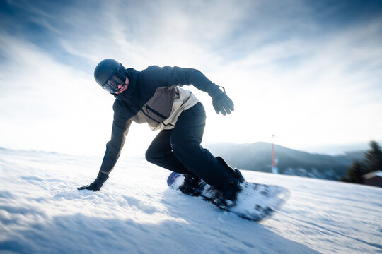 Snowboarder Carving Through Fresh Snow on Mountain Slope