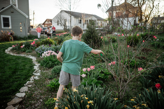 Child hunting Easter eggs in spring garden