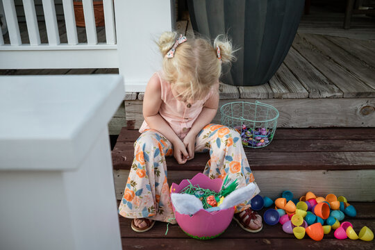 Little girl looking through Easter basket at goodies