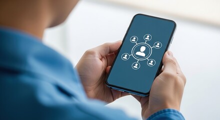 A close-up of a person holding a contemporary smartphone with a network connection icon showing a central user linked to multiple other profile symbols, signifying social media engagement and the crea