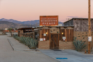 Obraz premium PIONEERTOWN, CALIFORNIA, UNITED STATES - Feb 7, 2026: Sign and building of the historic Pappy and Harriet's Pioneertown Palace