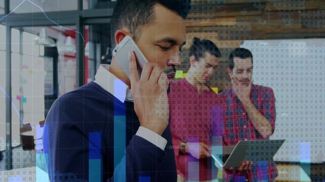 Man on phone gesturing, team examining laptop, phone call initiating bar charts linking tech data