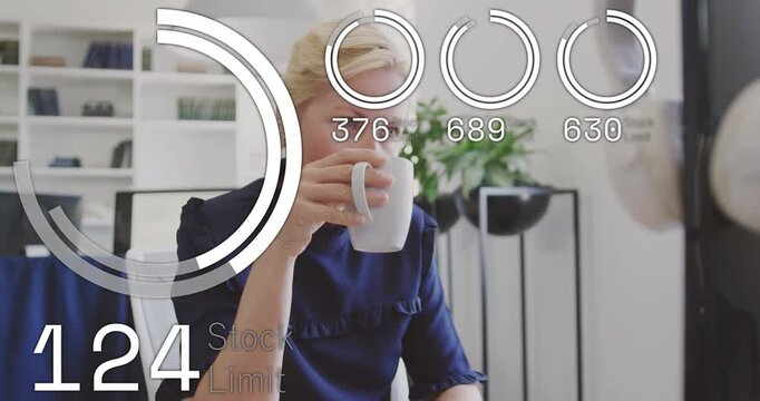 Female worker sipping mug at desk while watching finance HUD stock-limit rings rising, lowering mug