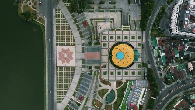 Aerial View of  Lam Vien square Artichoke Bud Landmark in Da Lat city, Vietnam
the unique yellow and green glass architecture, the surrounding paved square, and the clean geometric patterns of the urb