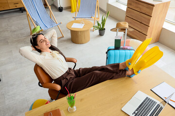 Happy businesswoman relaxing in office before vacation