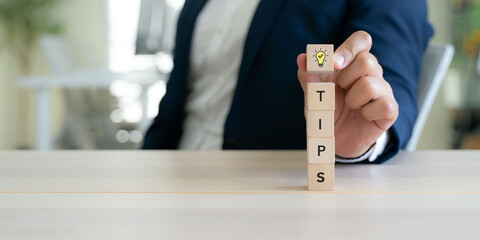 Quick Tips for Smart Solutions. A lightbulb icon block and wooden cubes spelling “TIPS