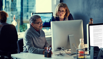 Fototapeta premium Motivated to make it through all their tasks. Shot of a group of businesspeople working late in an office.