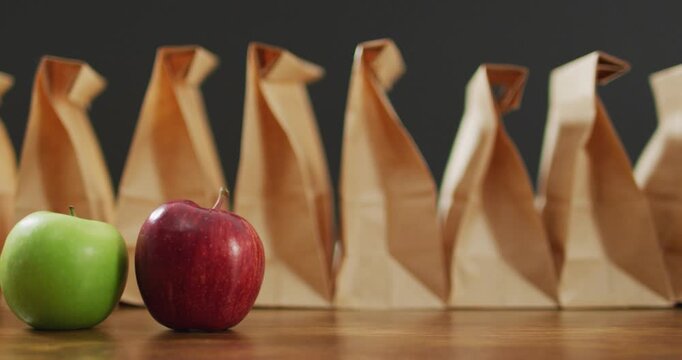 Animation of paper lunch bags an fruits on wooden table
