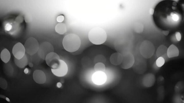 Dust Motes in a Light Beam A slow-motion shot of fine particles suspended in a strong, soft beam of light against an entirely dark, clean, and out-of-focus background, forming delicate, monotone