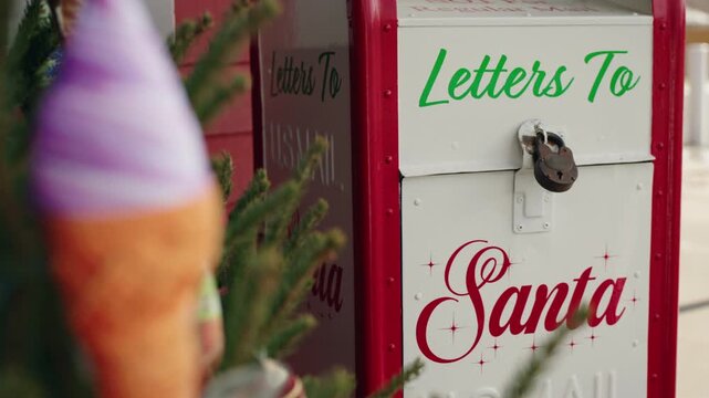 Outdoor mailbox for letters to Santa next to a decorated Christmas tree 