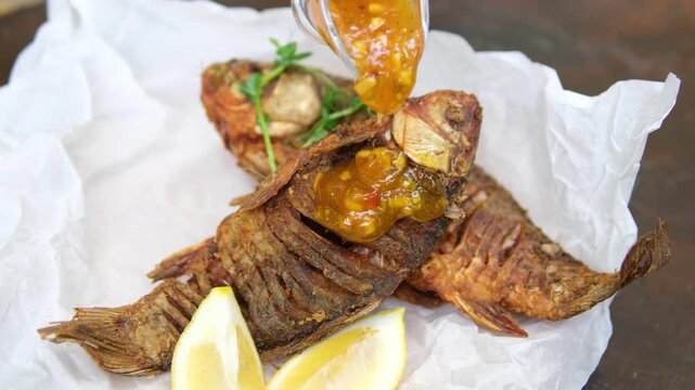 Overcooked fish, korai korob, pour yellow sauce, sweet and sour sauce, lemon, roast. High quality 4k footage
