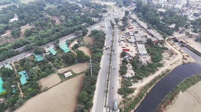 A top-down drone shot reveals intersecting roads, slow-moving traffic, and roadside activity&mdash;an atmospheric snapshot of urban movement and human routine.