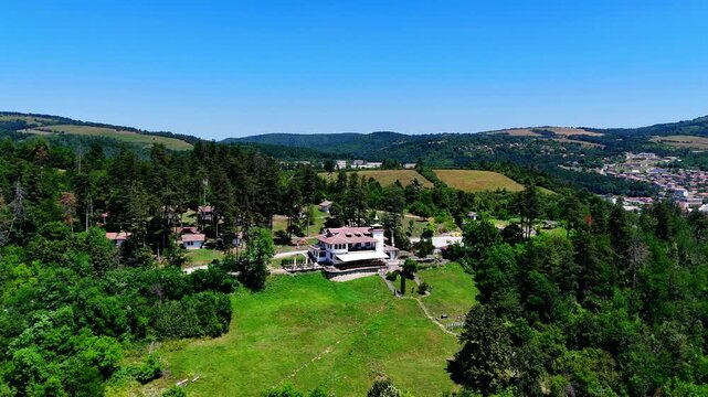 Drone orbits the Brushlyan Complex, highlighting its hilltop isolation with Tryavna village resting below in the valley.