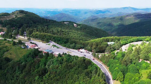 Push-in drone shot over the main Balkan road, revealing vast green hills and an expansive mountainous landscape stretching into the distance.