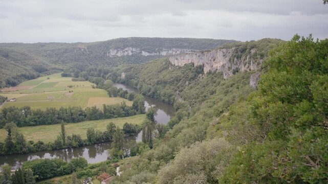 High angle view of winding river Lot surrounded by limestone cliffs and forest. Picturesque nature landscape near Saint G&eacute;ry in Occitanie region.