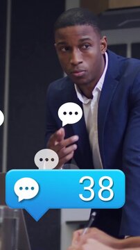 Vertical video: Mgr leaning in business meeting gesturing from blue chat counter rising peer noting