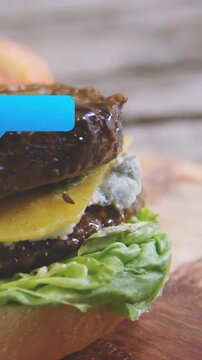Vertical video: Blue tag sliding in over burger causing sauce to pour moving away show texture