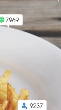 Vertical video: Sesame bun hovering starting badges popping over white plate fries showing likes