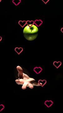 Vertical video: Hand releasing green apple, hearts drifting past while light forming soft scene