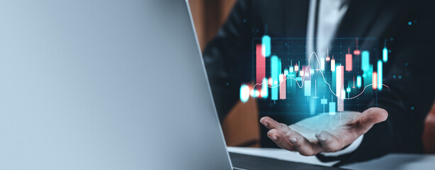 Businessman analyzing futuristic financial chart with holographic data and graphs concept on...