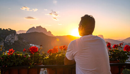 Man from behind sitting on a balcony with blooming geraniums looking into the sunset creating a peaceful and scenic view generative AI