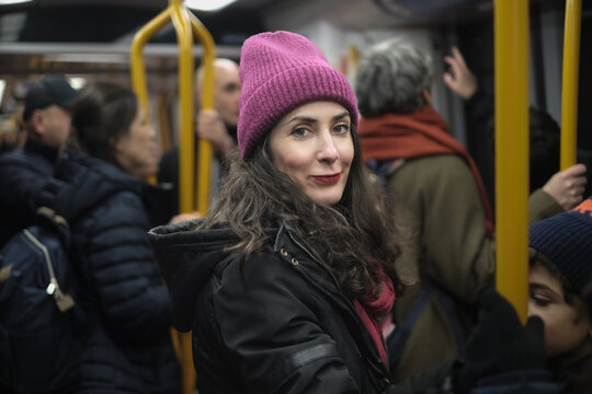Attractive Forty Year Old Woman Wearing a Winter Hat Traveling Standing on the City Metro