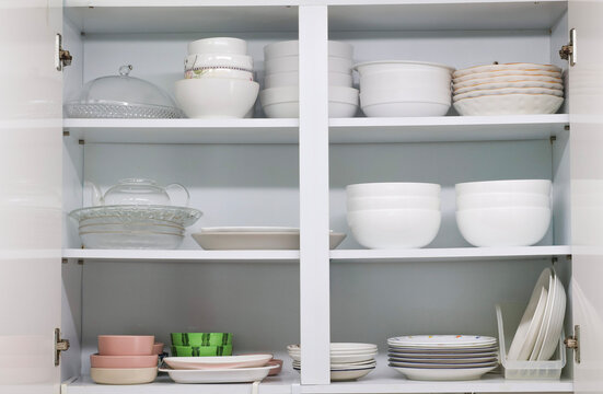 Open kitchen cabinet with neatly organized dishes and tableware