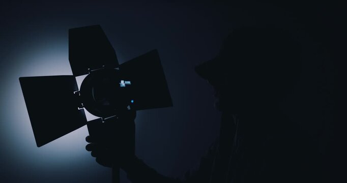 Lighting engineer setting up lights in film studio