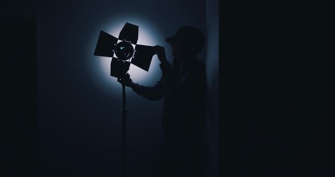 Lighting engineer setting up lights in film studio
