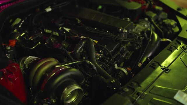 Detailed close-up view of a modified sports car engine with a large turbocharger, showcasing the intricate components and powerful build for high-performance racing and tuning concepts
